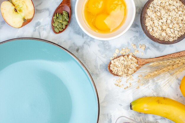 Acima vista do prato vazio azul e ingredientes para a comida saudável na mesa de gelo