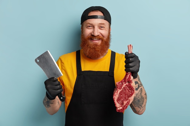 Açougueiro com barba ruiva segurando carne