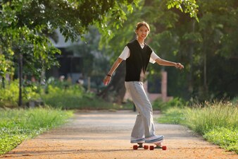 Actividade desporto estilo de vida menina asiática jogar surf skate no parque conceito saudável e exercício