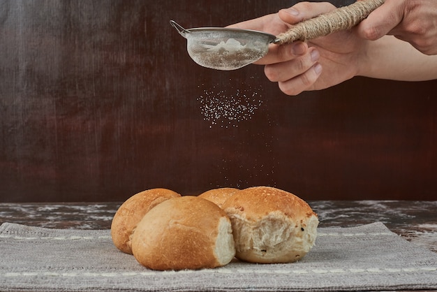 Adicionar pó branco ao bolo de pão.