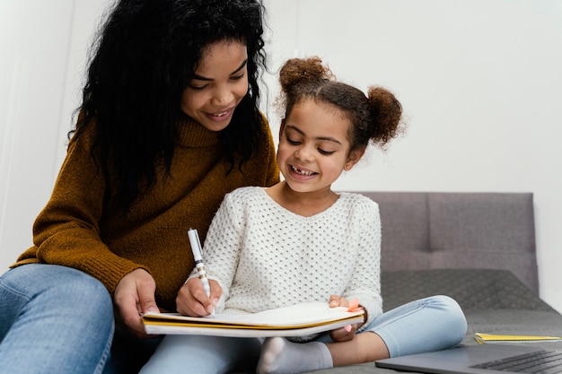 Adolescente ajudando a irmã com a escola online