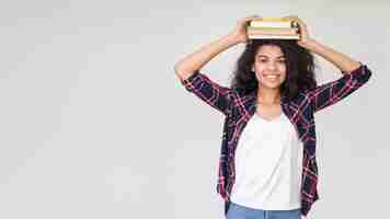 Foto grátis adolescente brincalhão de cópia-espaço com livro na cabeça