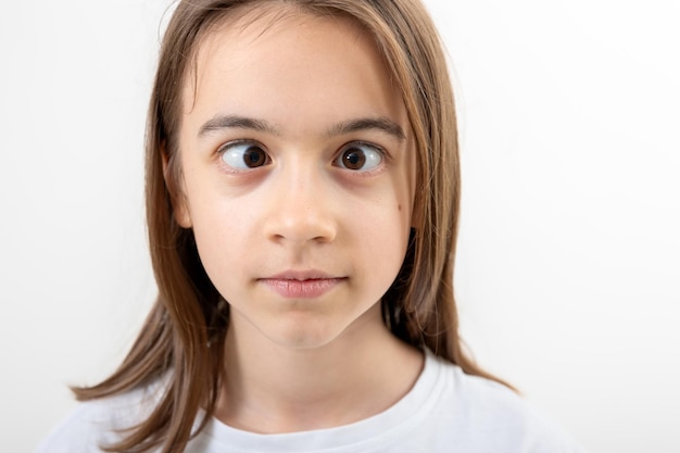 Adolescente caucasiana faz caretas em um fundo branco isolado