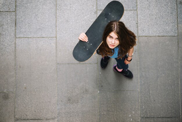 Foto grátis adolescente com skate olhando