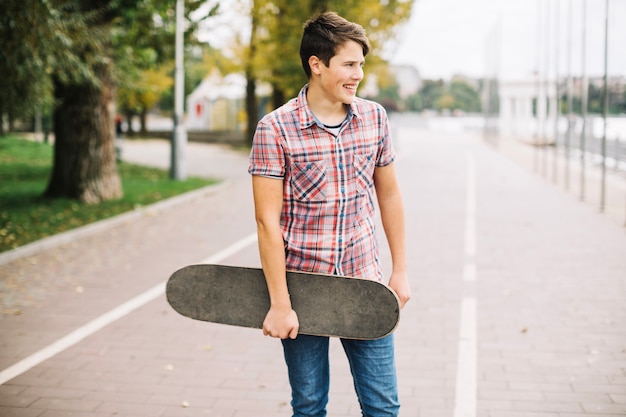 Adolescente com skateboard na pista da bicicleta