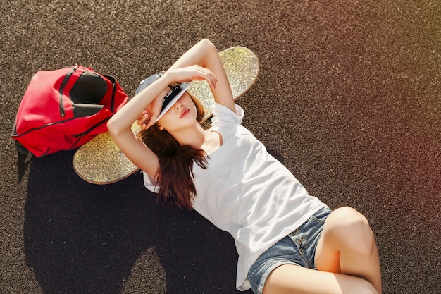 Adolescente com t-shirt branca que descansa no skate