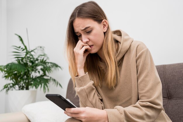 Adolescente com telefone em casa