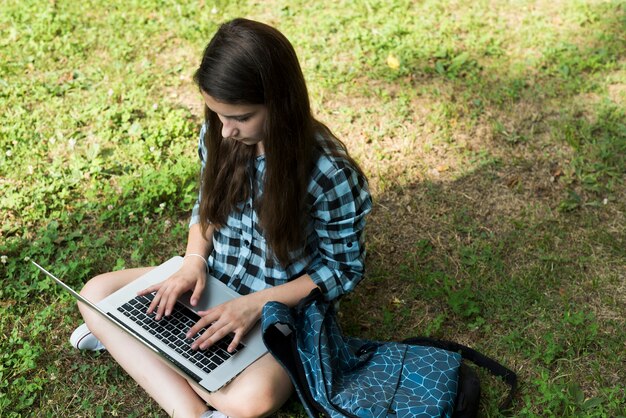 Adolescente de alto ângulo trabalhando no laptop