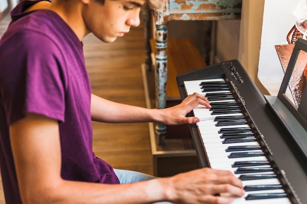 Adolescente de colheita tocando piano