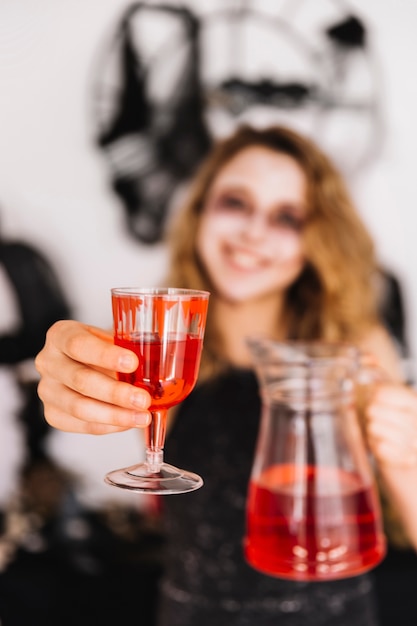 Adolescente de Halloween com bebidas vermelhas