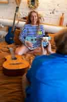 Foto grátis adolescente e menina gravando música em seu estúdio caseiro com guitarra