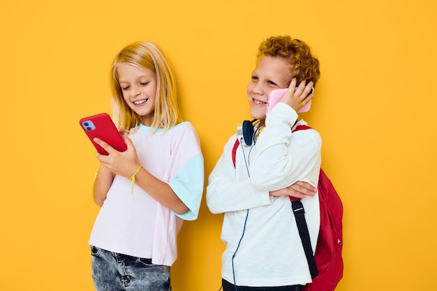 Adolescente e menina olhando para o fundo isolado de comunicação de entretenimento de telefone Foto Premium