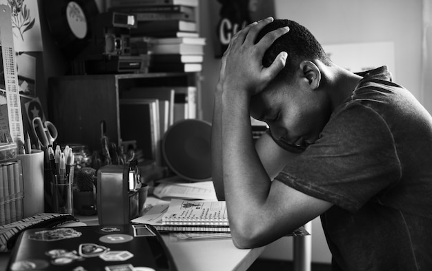 Adolescente em um quarto fazendo trabalho estressado e frustrado