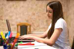 Foto grátis adolescente fazendo a lição de casa e navegando na internet