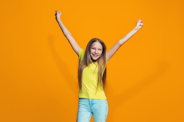 Adolescente feliz sucesso comemorando ser um vencedor. Imagem energética dinâmica do modelo feminino