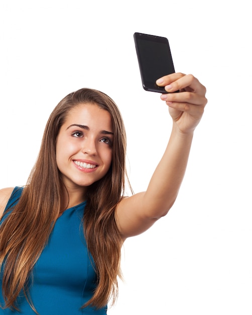 Adolescente feliz usando sua câmera no fundo branco