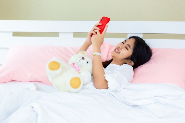 Adolescente feminino usar smartphone na cama