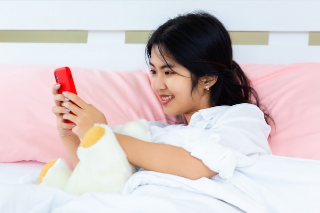 Adolescente feminino usar smartphone na cama