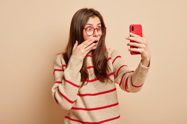 Adolescente gengibre usando óculos vermelhos