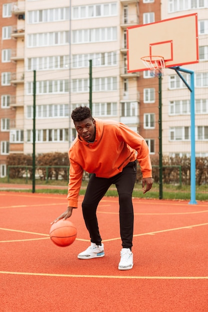 Adolescente jogando basquete ao ar livre