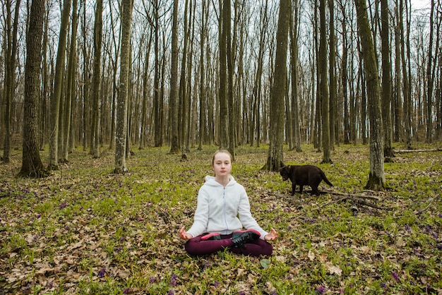 Adolescente meditando na floresta
