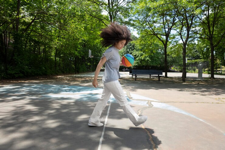 Foto grátis adolescente negra sorridente jogando basquete