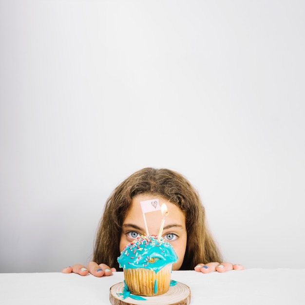 Foto grátis adolescente olhando cupcake