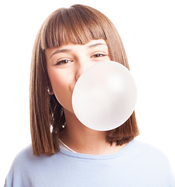 Adolescente que faz uma bolha com goma de mascar