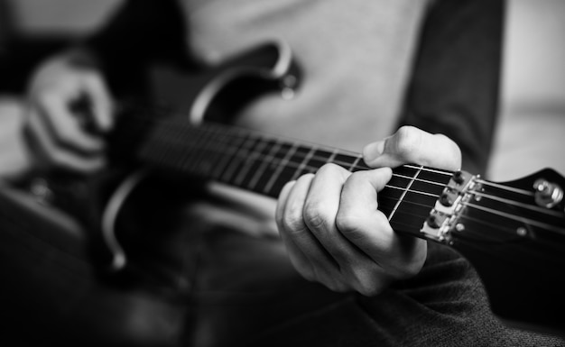 Adolescente que joga uma guitarra elétrica em um passatempo do quarto e no conceito da música