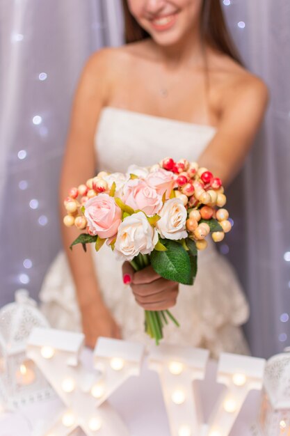 Adolescente, segurando um buquê de flores na frente dela