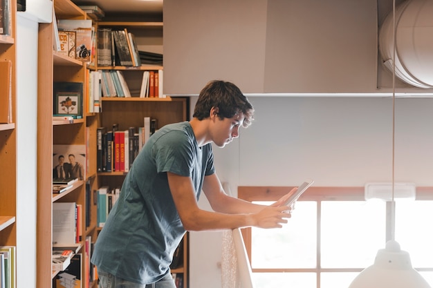 Adolescente, usando, tabuleta, perto, trilhos, em, biblioteca