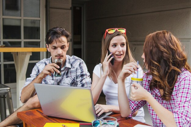 Adolescentes com bebidas e laptop