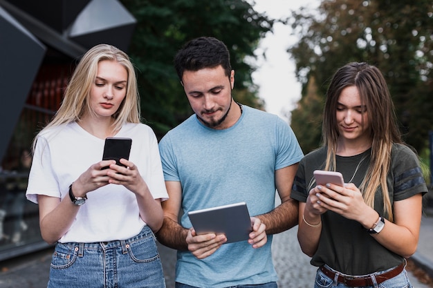 Adolescentes de médio porte verificando seus telefones