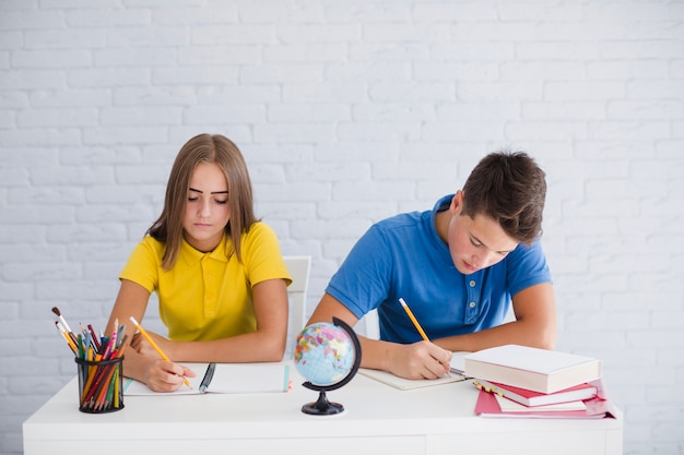 Adolescentes fazendo anotações na aula