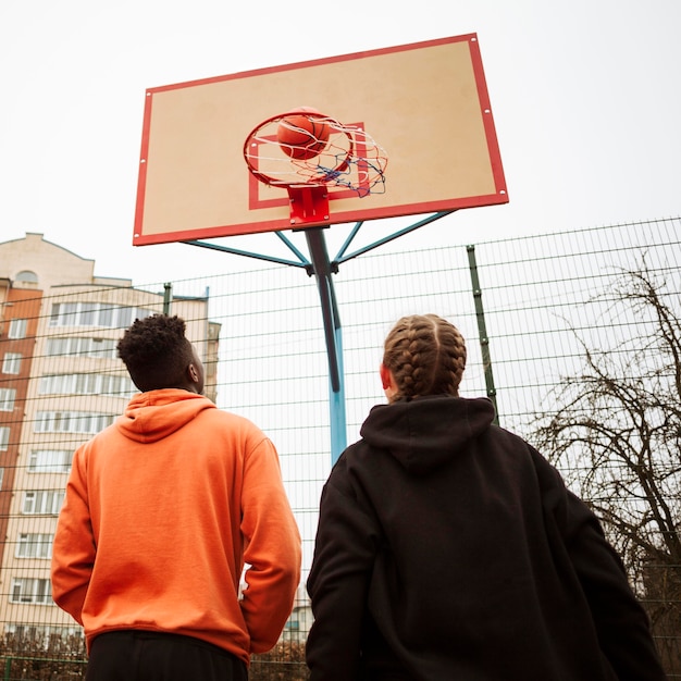 Foto grátis adolescentes jogando basquete ao ar livre