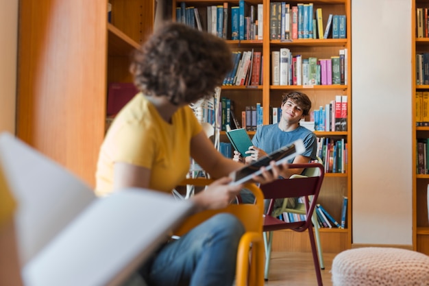 Adolescentes, olhando um ao outro, em, biblioteca