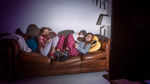 Adolescentes relaxando na sala de estar com tv