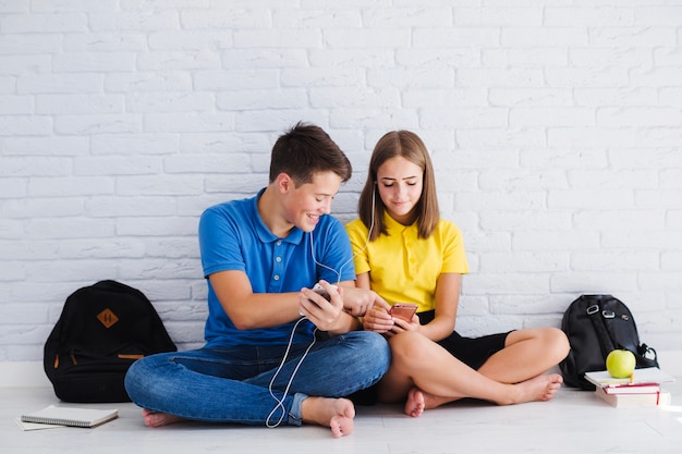 Adolescentes sorridentes ouvindo música juntos