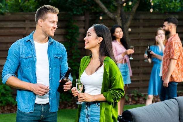 Adoráveis amigos olhando uns aos outros com bebidas