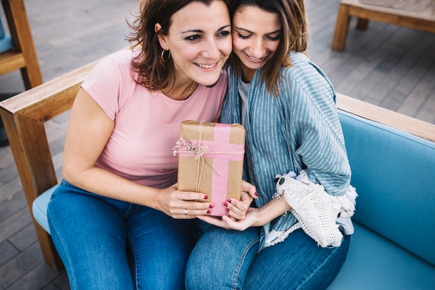 Adoráveis ​​mulheres com presentes no sofá