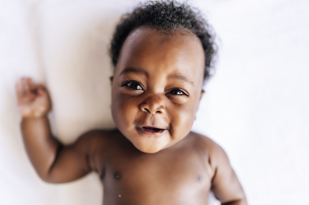 Foto grátis adorável bebê alegre deitado na cama