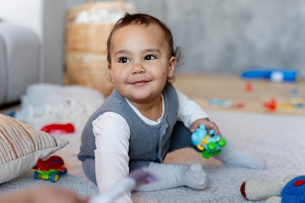 Adorável bebê brincando no chão com brinquedo