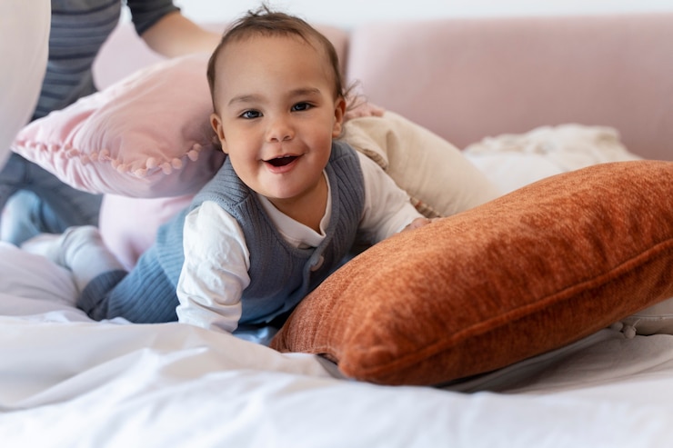 Foto grátis adorável bebê rindo e brincando com sua mãe na cama