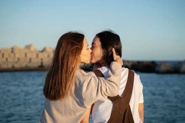 Adorável casal de lésbicas se beijando ao ar livre