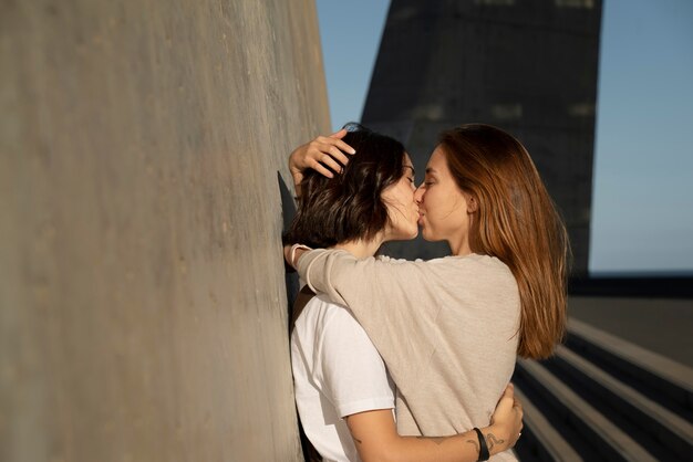 Adorável casal de lésbicas se beijando ao ar livre