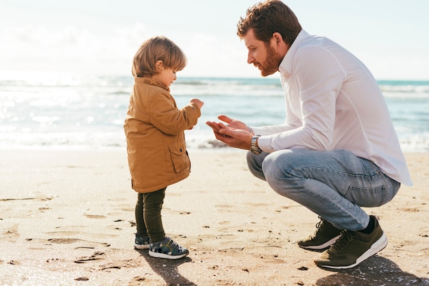 Adorável criança se familiarizando com a areia da praia