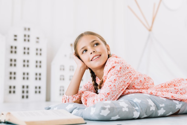 Foto grátis adorável garota feliz posando com um livro