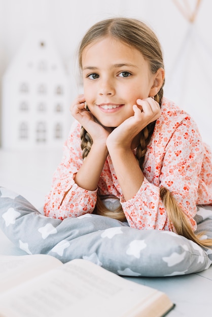 Foto grátis adorável garota feliz posando com um livro