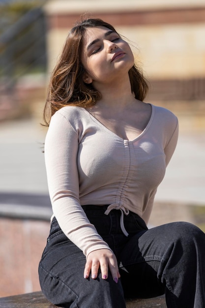 Adorável garota sentada sob o sol e se bronzeando Foto de alta qualidade
