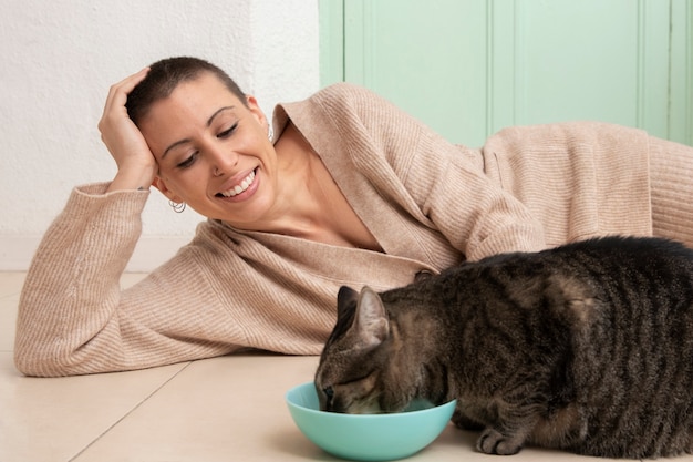 Adorável gatinho comendo ao lado de seu dono